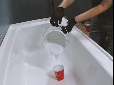 Liquid porcelain liner being poured and applied into a bathtub